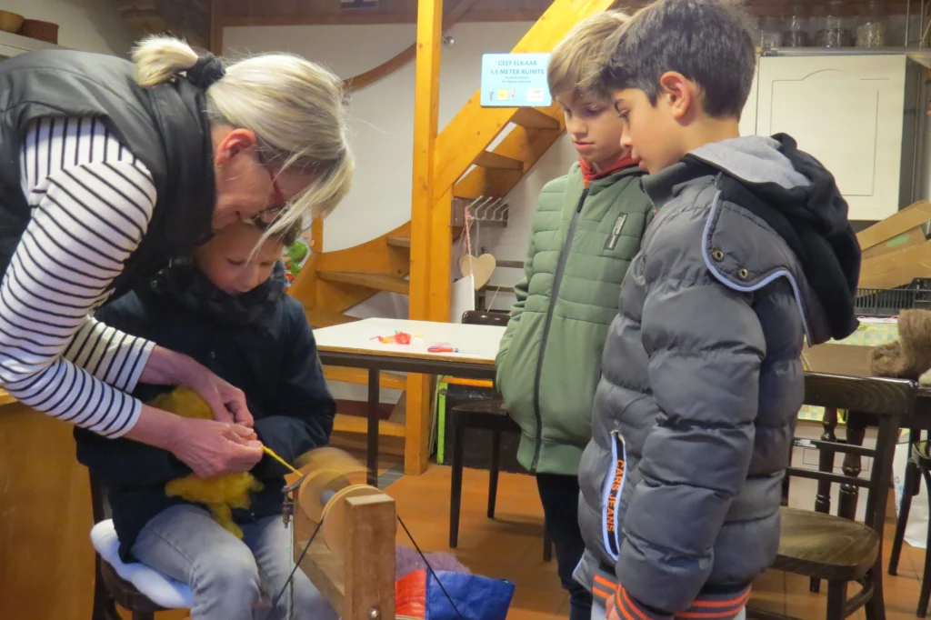 Kinderen leren spinnen bij schoolproject Oude ambachten